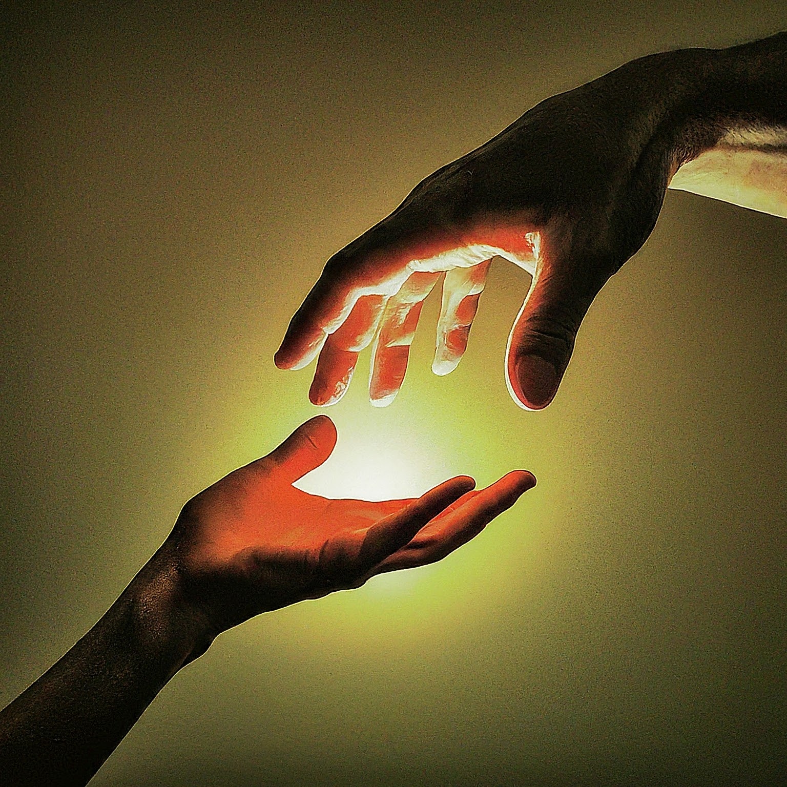 Two hands reaching toward light